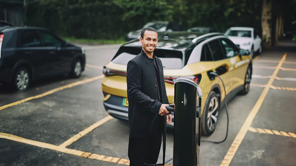 A man charges his electric vehicle at an EV chargepoint.