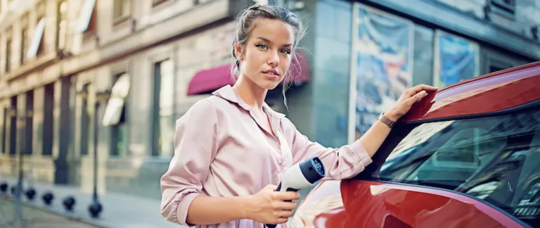 woman driver electric vehicle ev charging station charge point