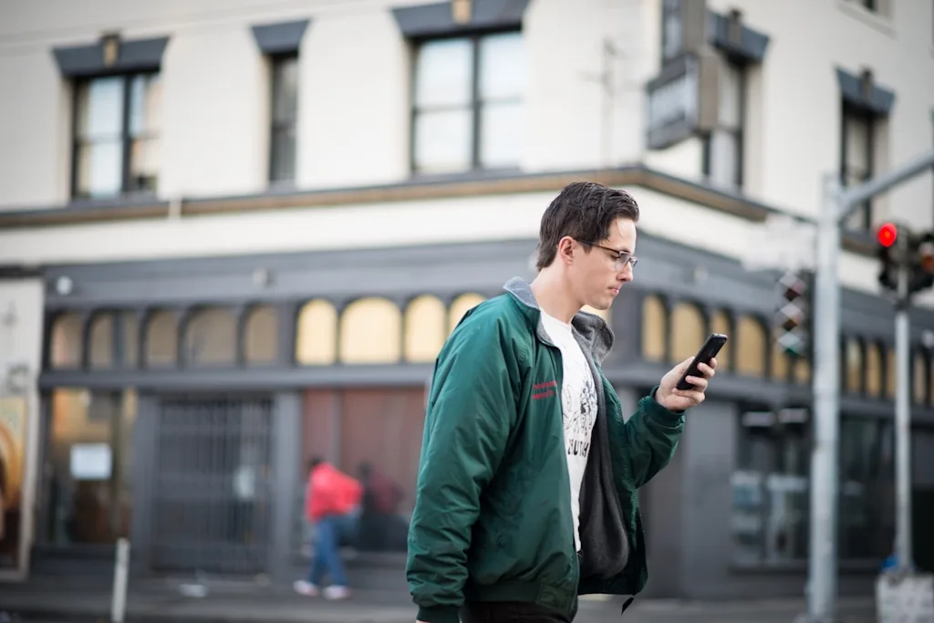 young man looking at his phone t20 jop0kz blog