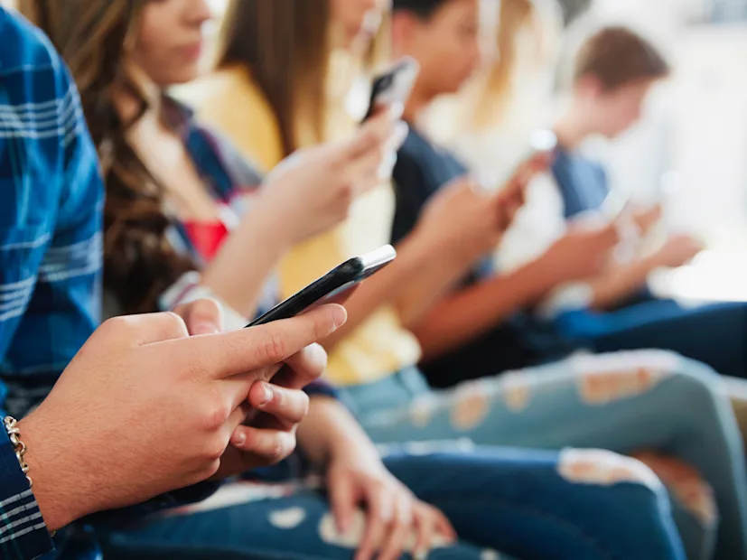 A group of high school students using their cellphones