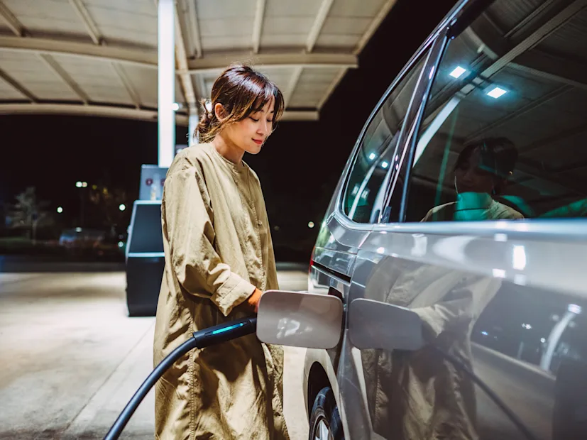 woman driver connected driving car electric ev charging charger charge station point battery hydrogen.png